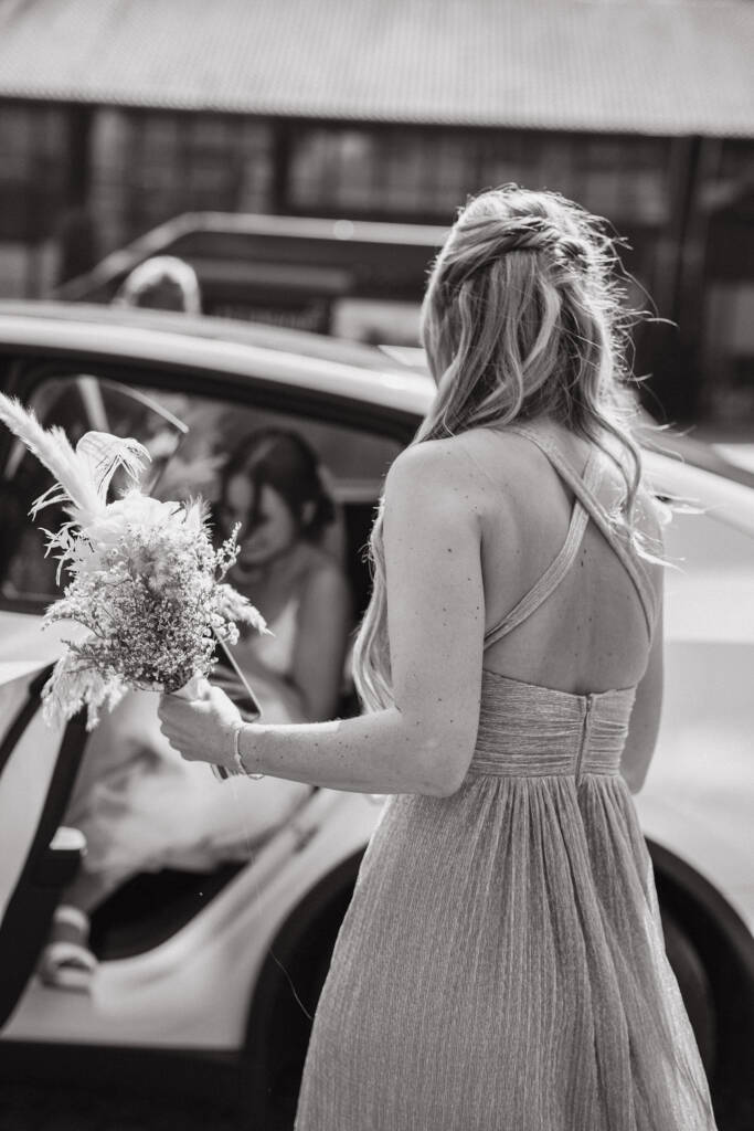 Trauzeugin hilft Braut aus Auto - Hochzeitsfotograf Niederrhein