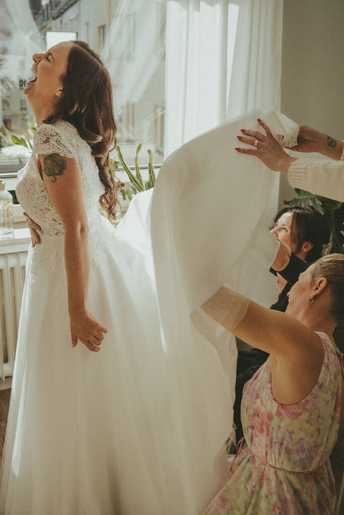 Brautjungfern müssen bei Getting Ready unters Brautkleid krabbeln - Hochzeitsfotograf Moers