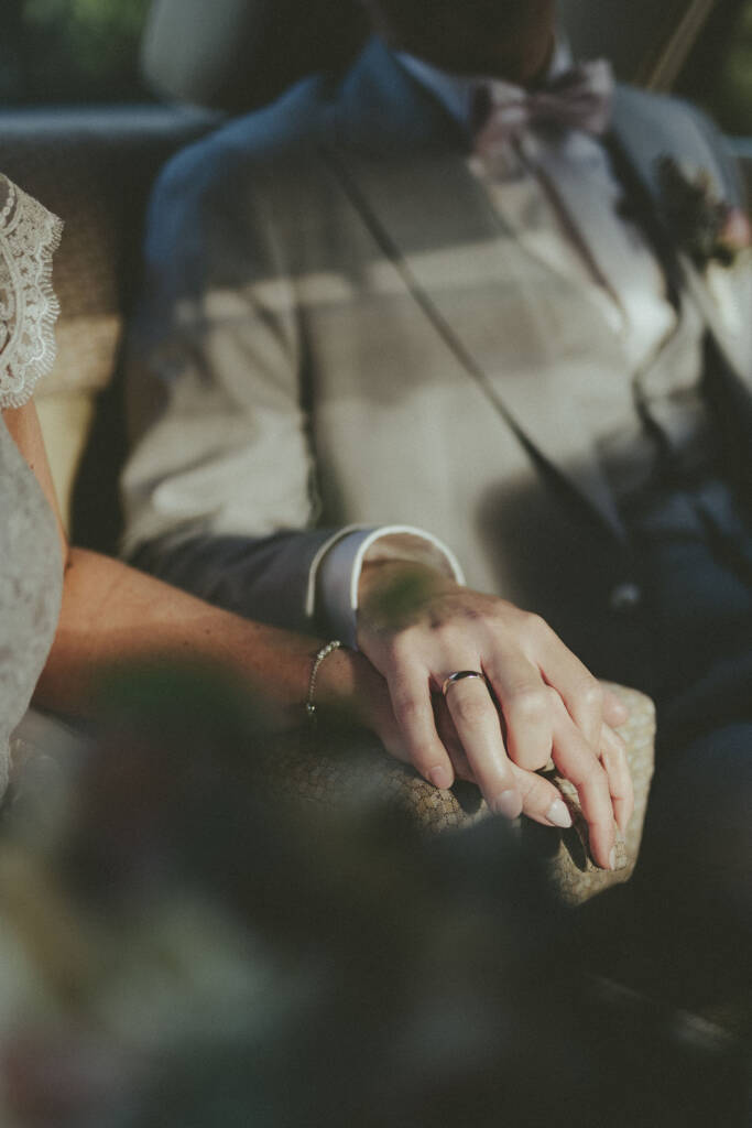 Brautpaar hält Händchen im Hochzeitsauto - Hochzeitsfotograf Moers