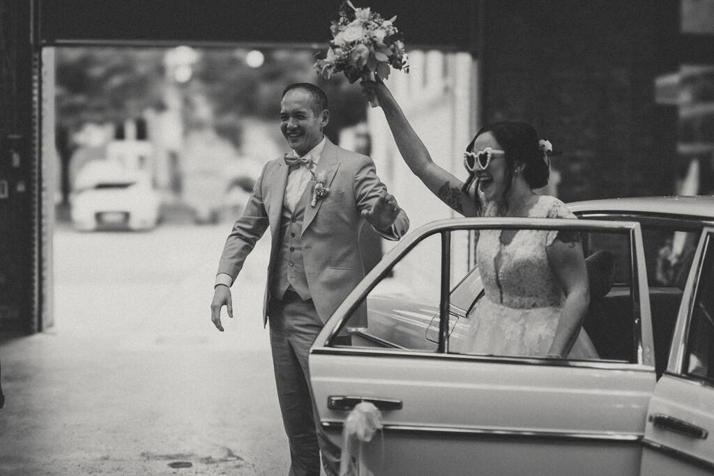 Brautpaar steigt jubelnd aus Oldtimer aus - Hochzeitsfotograf Moers