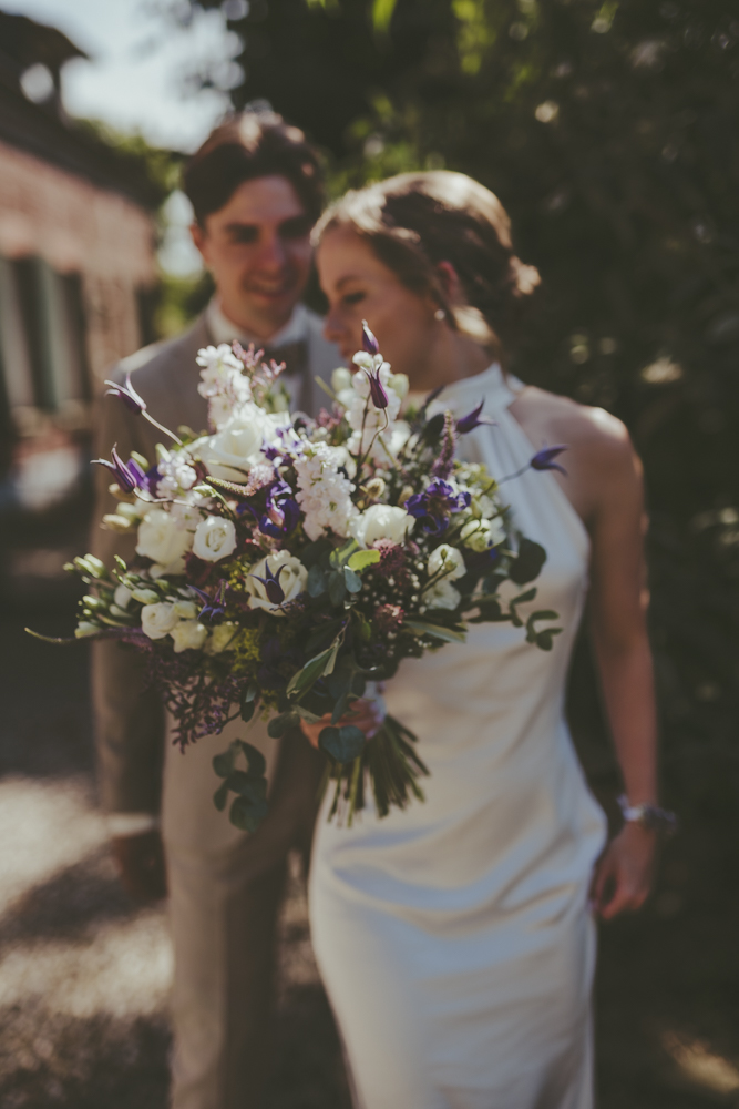 Brautpaar vor freier Trauung hält Brautstrauss in die Kamera - Hochzeitsfotograf Kevelaer